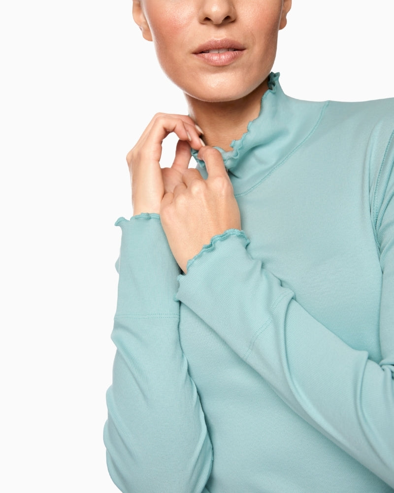 Close-up of fine ribbed cotton fabric and subtle rolled hem detail