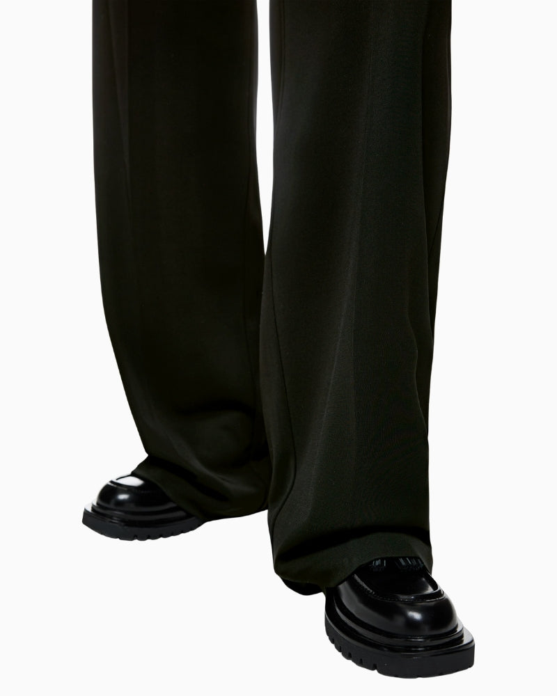 Close-up of waistband, fastening button and subtle crease detail on Marc Cain trousers