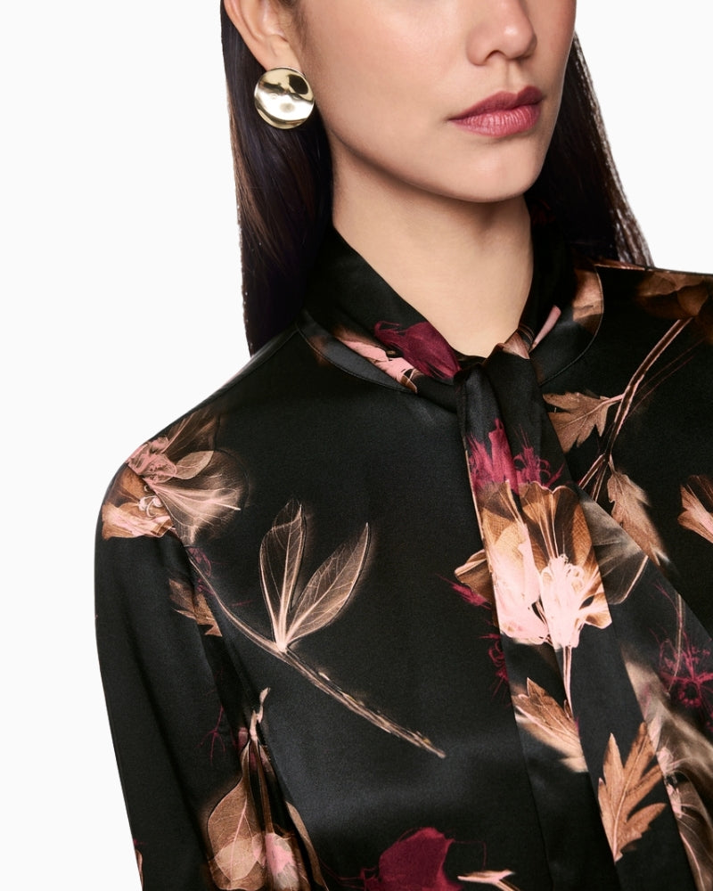 Close-up of bow detail and floral pattern on silk blouse