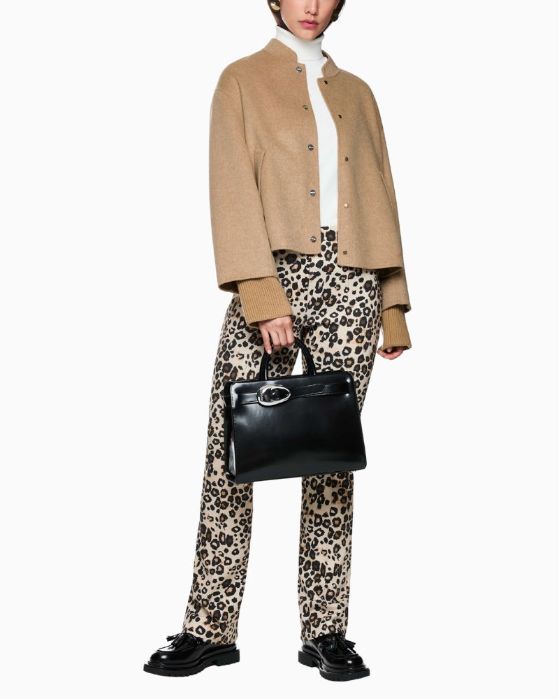 Model wearing sand wool jacket with neutral trousers and loafers