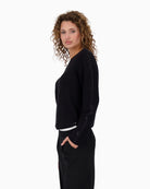 Side of Monari black knit top styled with trousers for a polished casual outfit
