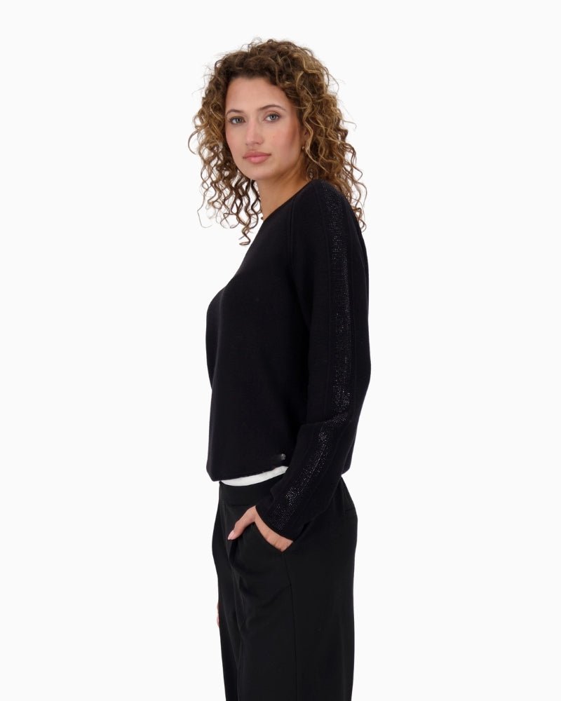 Side of Monari black knit top styled with trousers for a polished casual outfit