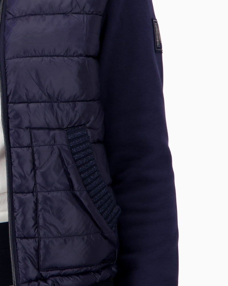 Close-up of Monari logo patch on quilted polyamide fabric