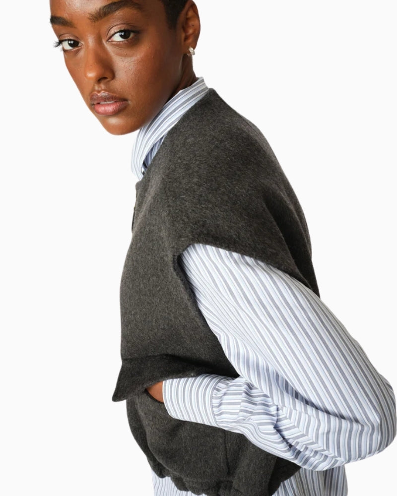 Side view of wool vest showing flap pockets and sleeveless cut