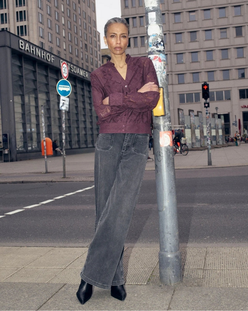 Model wearing black lace shirt by Mos Mosh styled over a camisole for smart-casual look