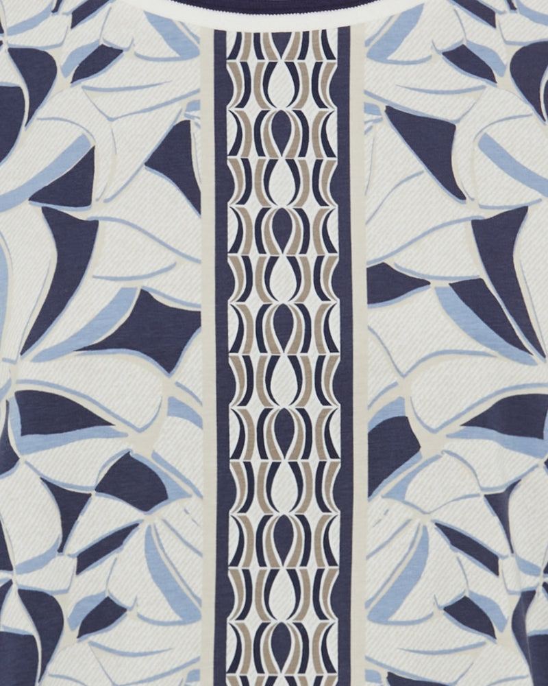 Close-up of modified crew neckline on patterned navy top