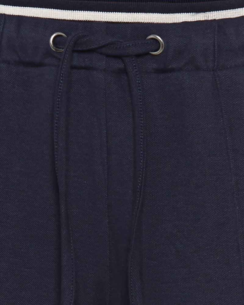 Close-up of contrast waistband and pleat stitching