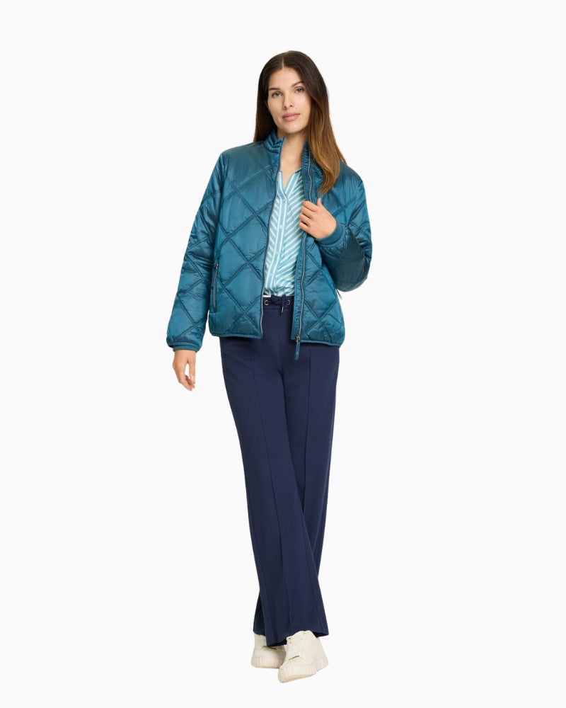 Olsen teal quilted jacket with zip closure paired with wide leg trousers