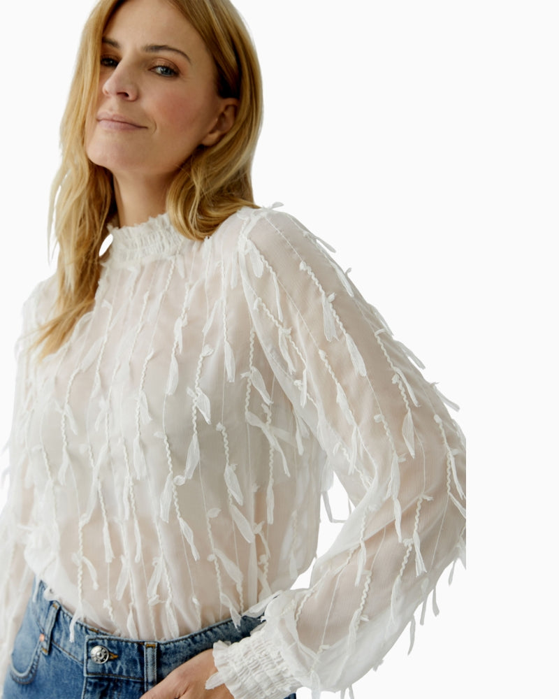 Side view of Oui white blouse draping naturally over trousers