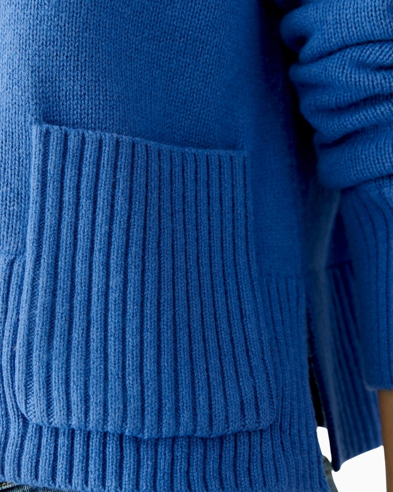 Close-up of rib neckline with rolled edge in blue knit