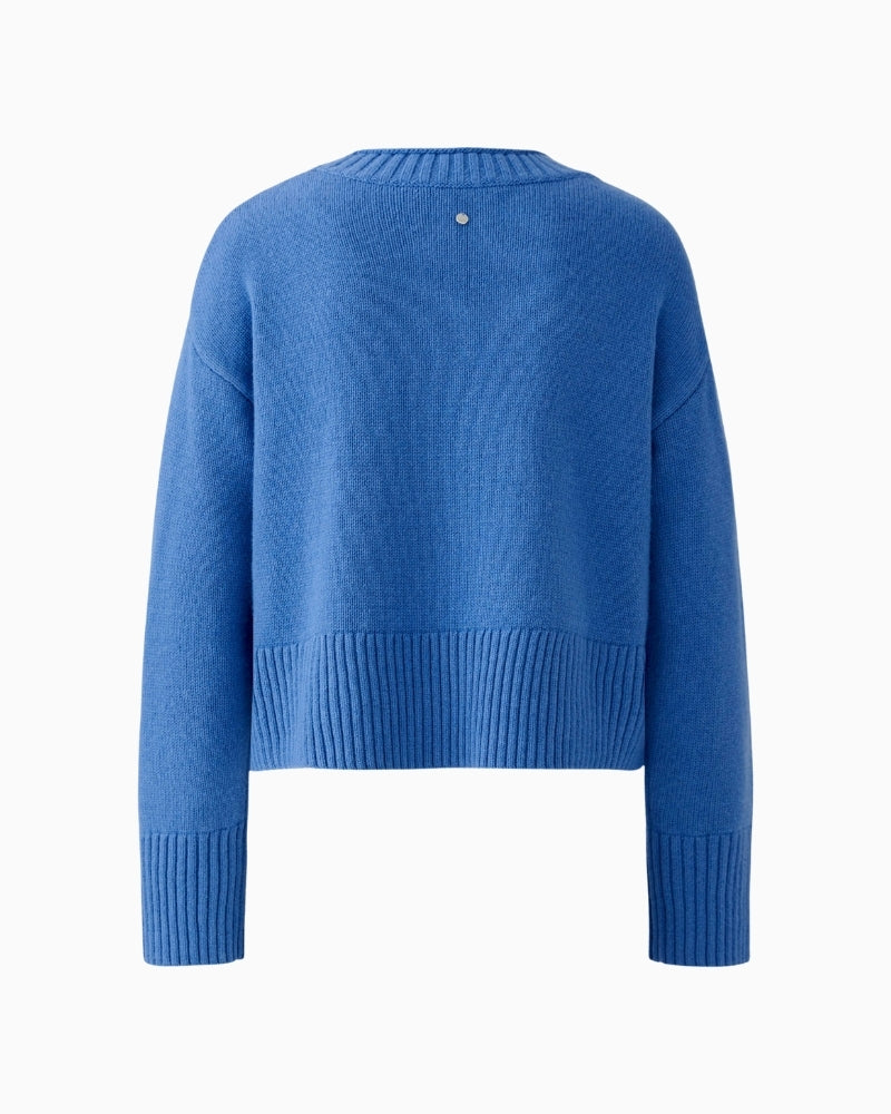 Back view of blue cropped pullover with overcut shoulders