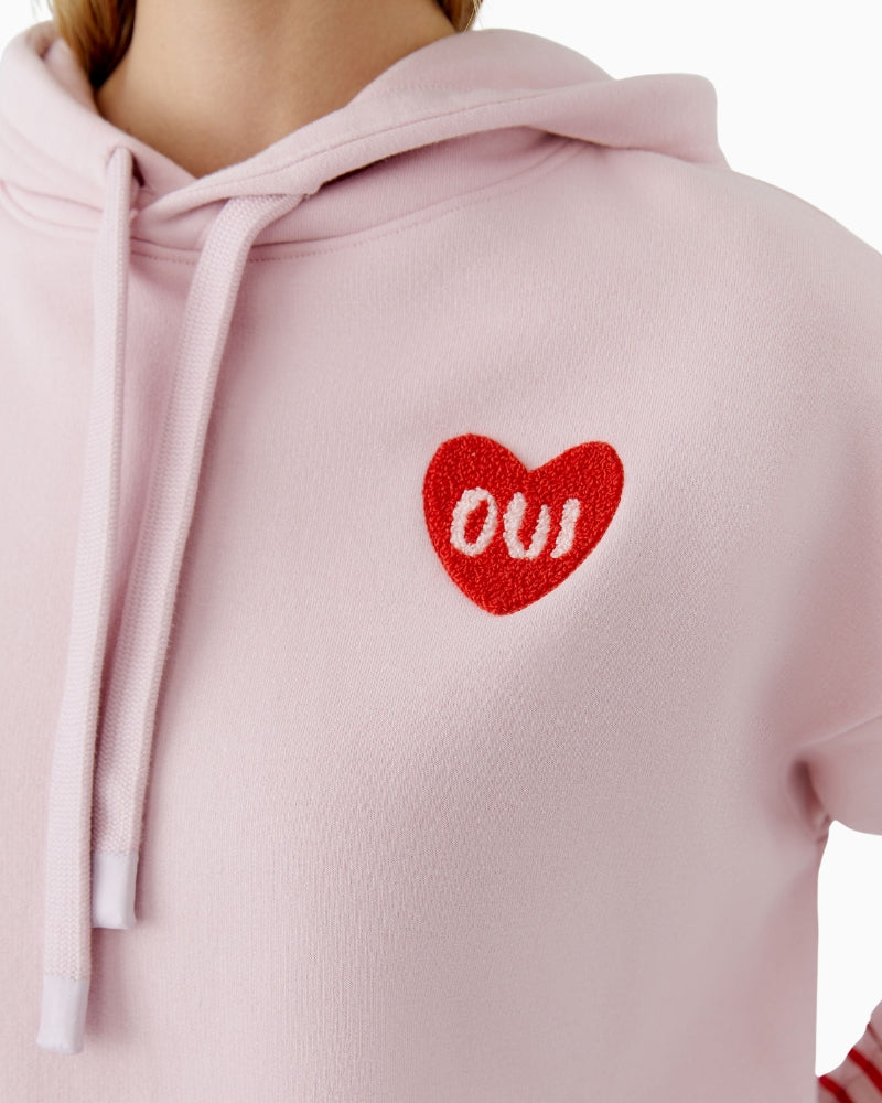 Close-up of heart logo detail on Oui hoodie in soft mauve shade