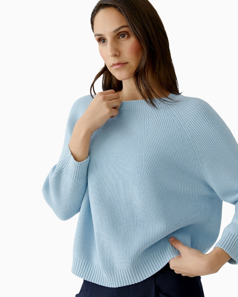 Woman wearing Oui light blue pullover, relaxed pose showing oversized fit – Áines Boutique