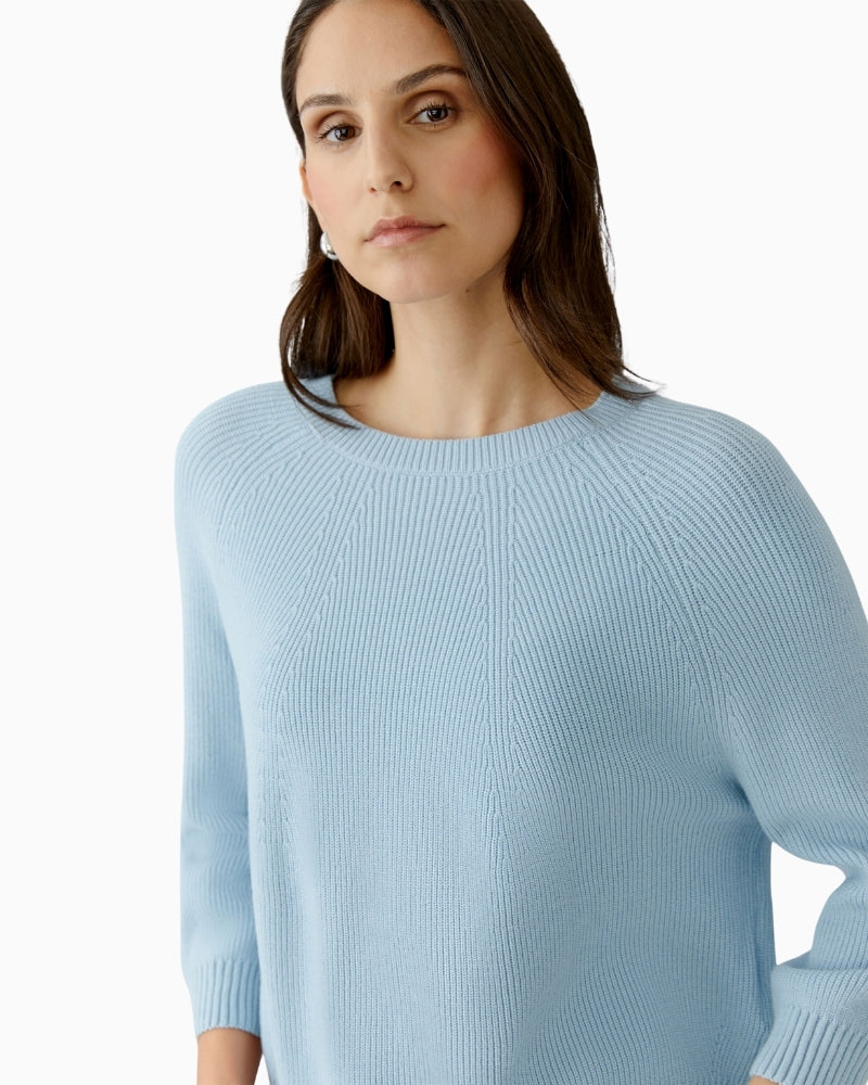 Woman wearing Oui light blue pullover with hands in pockets, side angle – Áines Boutique