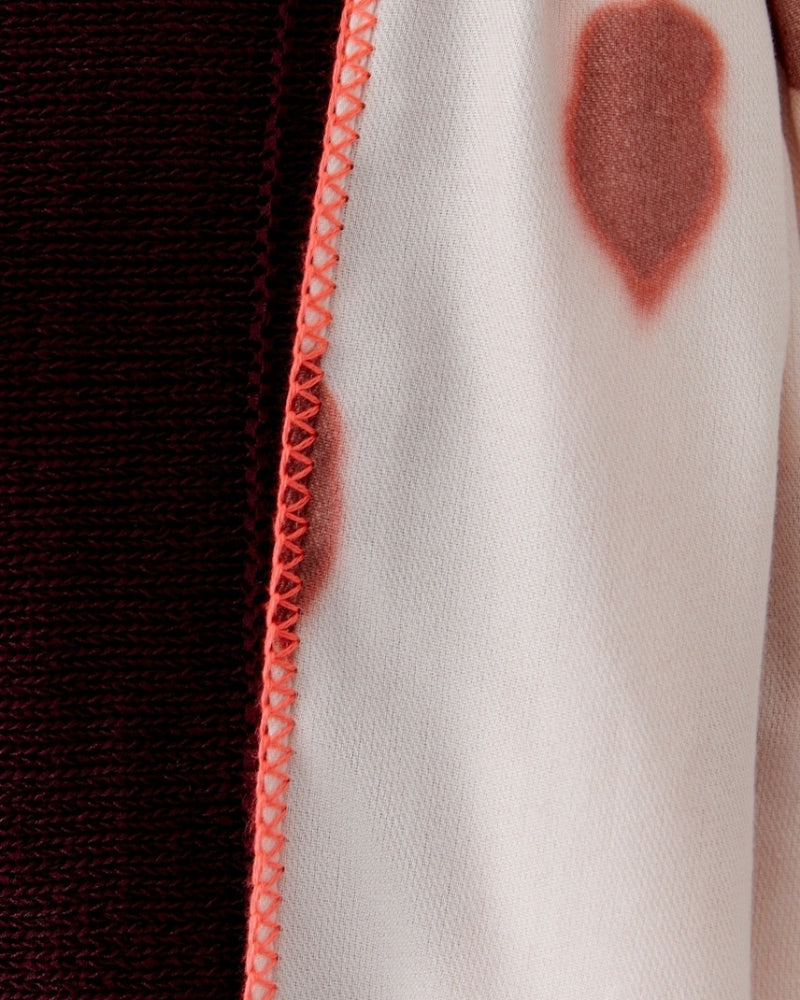 Close-up of embroidered hem detail on Oui rose red scarf