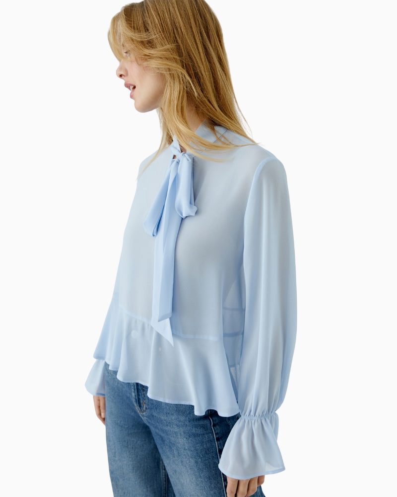 Side view of relaxed-fit blue blouse with buttoned cuffs