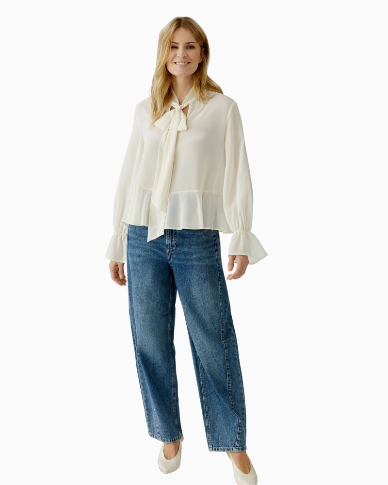 Off-white blouse styled with tailored trousers for workwear look
