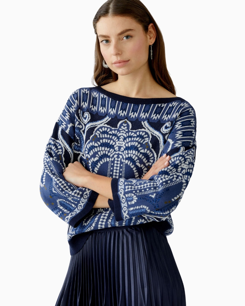 Close-up of neckline and metallic detailing in jacquard knit fabric