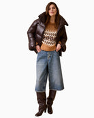 Lifestyle view of model wearing Oui jacquard pullover with casual trousers, bomber jacket and boots