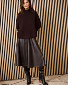 Model wearing dark brown Oui A-line faux leather midi skirt with brown sweater