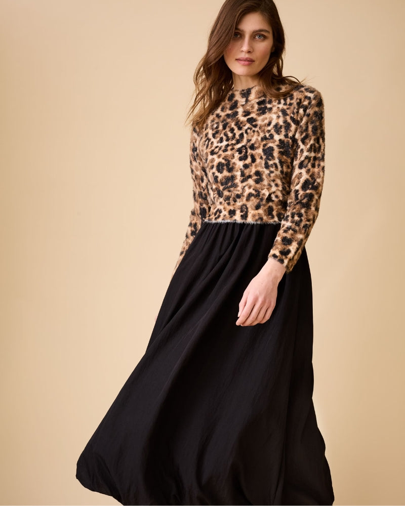 Lifestyle view of model wearing Oui leopard pullover paired with black midi skirt