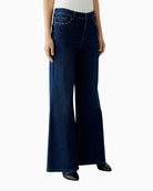 Side view showing ockets and side seams of dark blue jeans