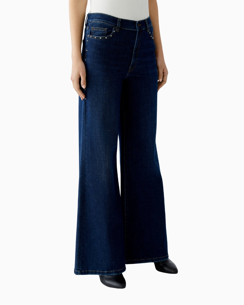 Side view showing ockets and side seams of dark blue jeans