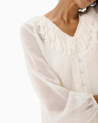 Close-up of front button closure and delicate neckline ruffle detail
