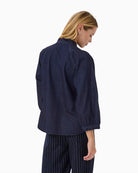Back view of cotton denim blouse with soft structure and cropped sleeves