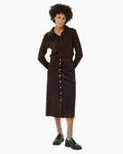 Model wearing brown midi skirt styled with knit jumper and boots