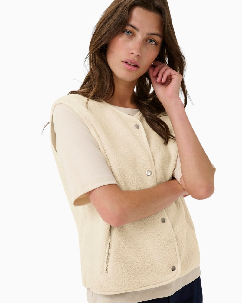 Close-up of snap-button front and pocket detail on teddy vest