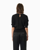 Back view of black shimmer blouse with regular fit and clean finish