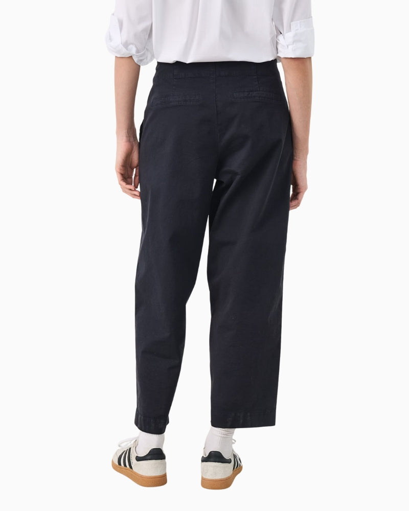 Close-up of waistband and pocket detail on navy trousers