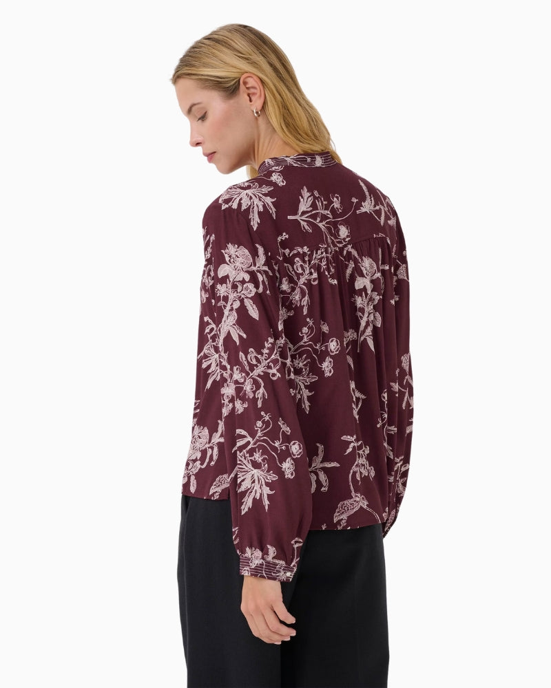 Side view of relaxed fit blouse in rich port shade with subtle print