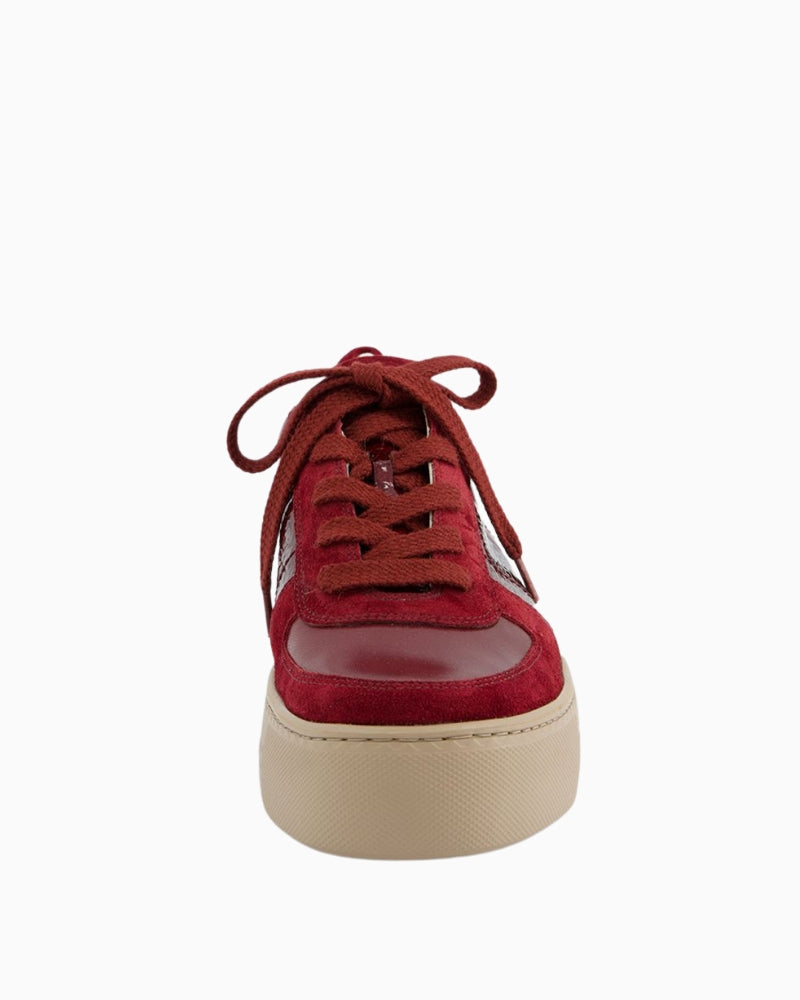 Close-up of suede and patent leather detail on red sneakers