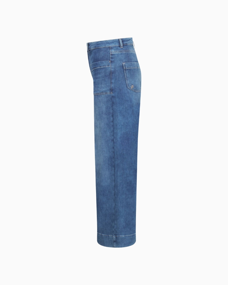 Side view showing soft denim drape and deep hem