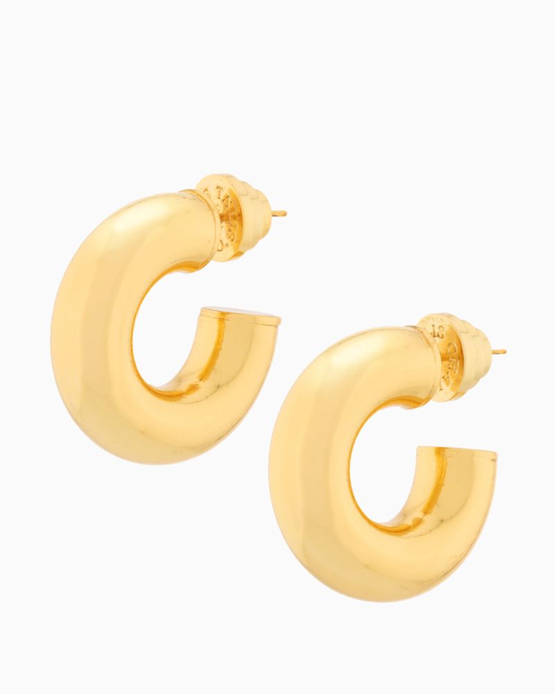 Close-up of chunky gold hoop earrings showing smooth rounded design
