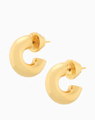 Close-up of small gold huggie hoops in rounded chunky design