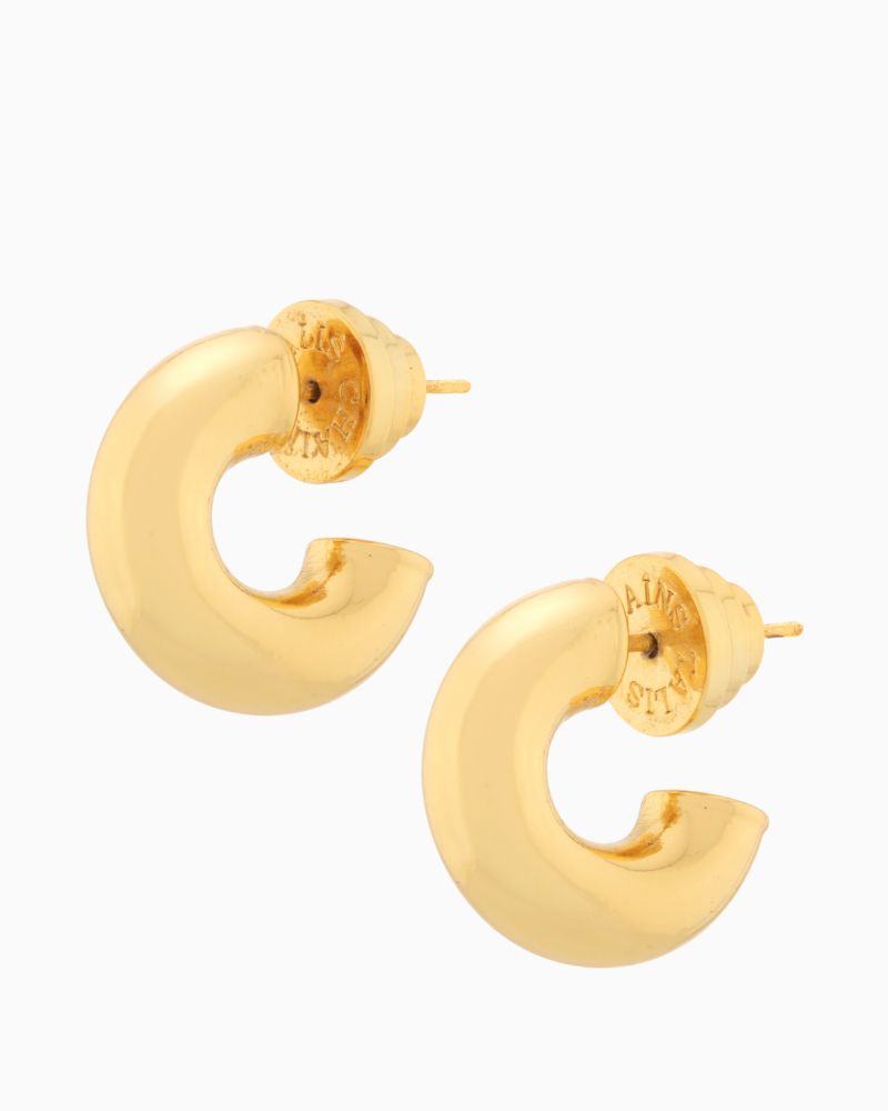 Close-up of small gold huggie hoops in rounded chunky design