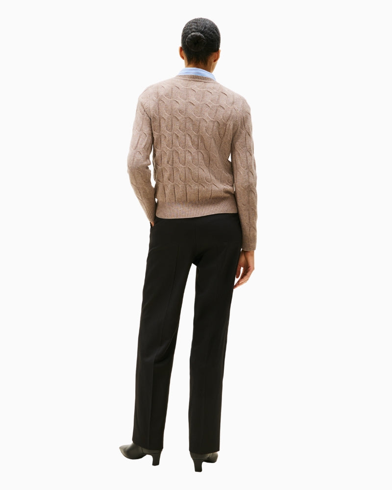 Back view of hip-length beige cable-knit sweater