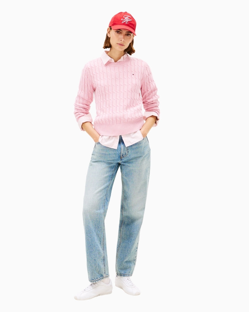 Model wearing pink Tommy jumper styled with light jeans