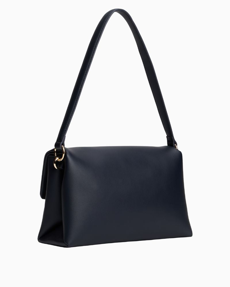 Back of Tommy Hilfiger navy shoulder bag with monogram plaque and removable crossbody strap