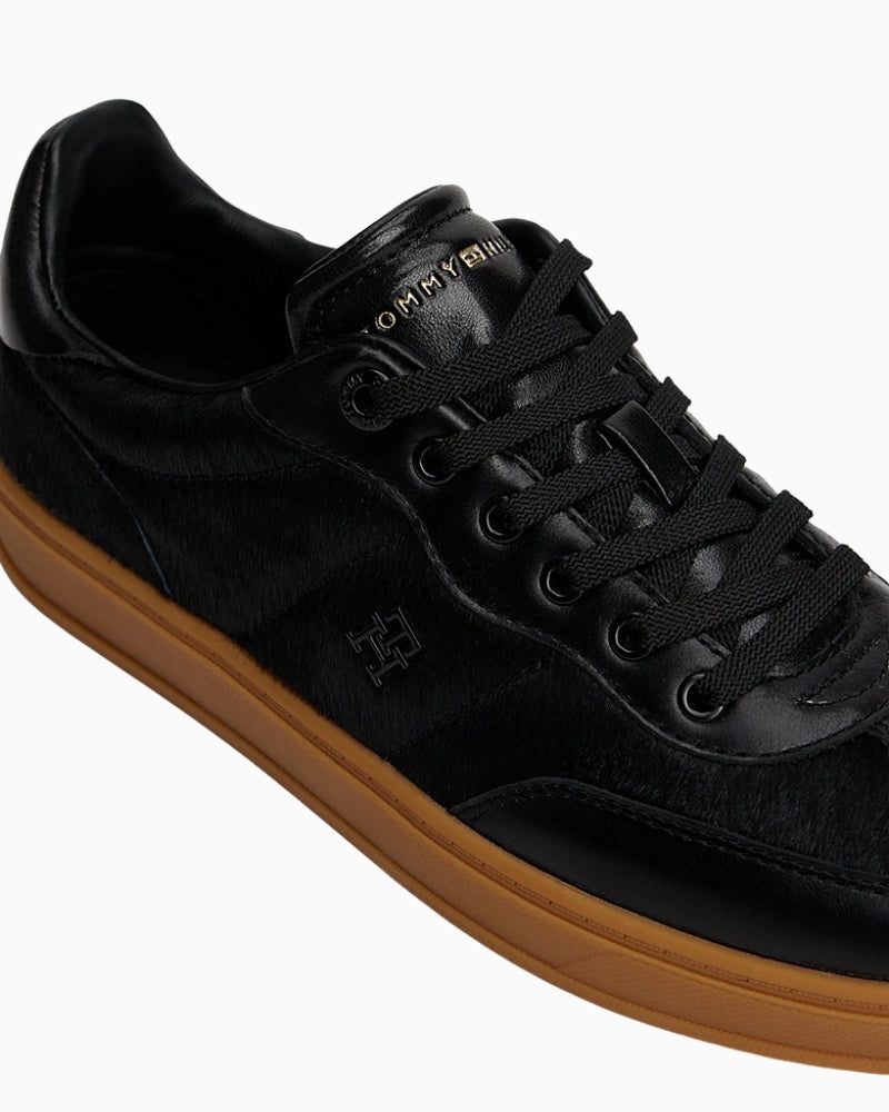 Close up of Tommy Hilfiger monogram trainers with leather and suede textures