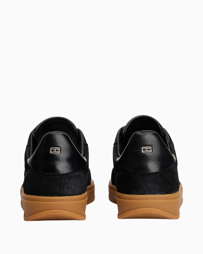 Back view of trainers with metallic flag logo embossed on heel