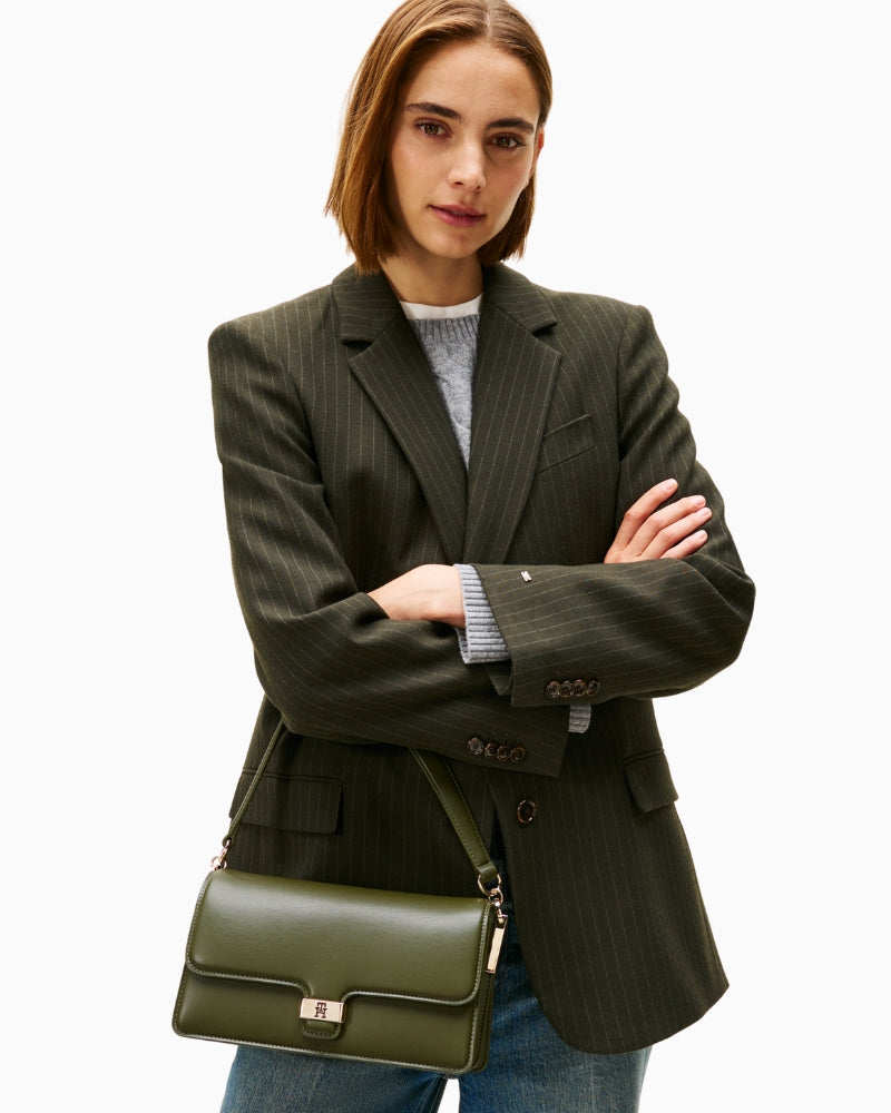 Tommy Hilfiger crossbody worn on shoulder with flap closure visible