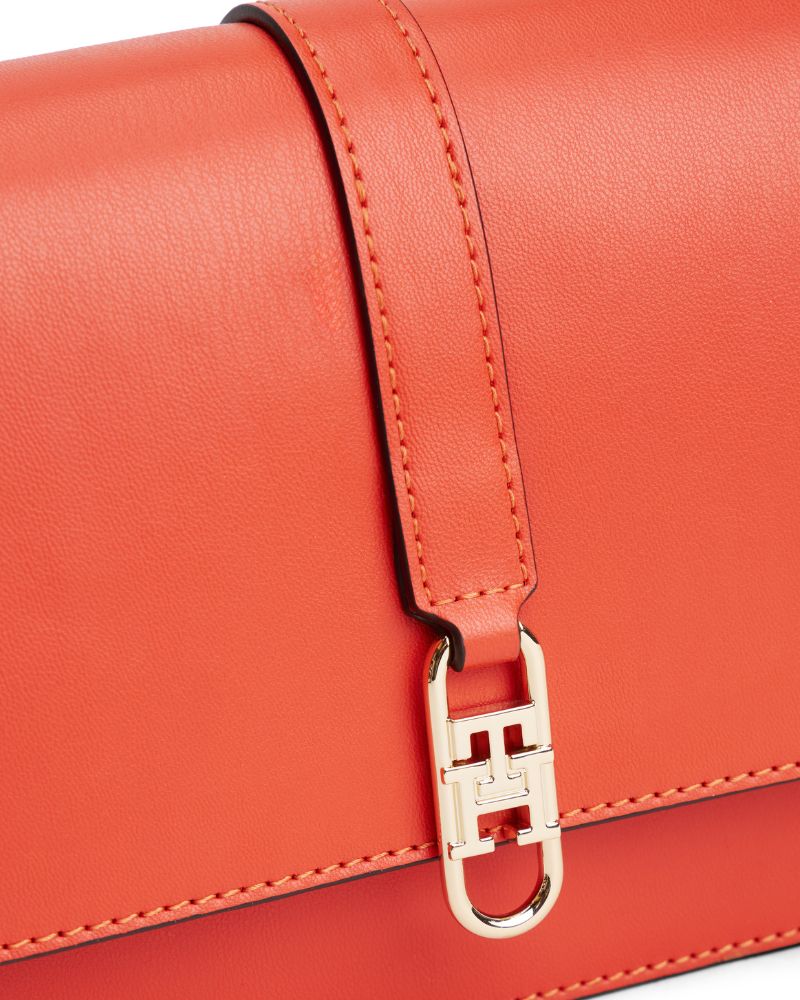 Front view of Tommy flap bag in orange faux leather with gold logo detail