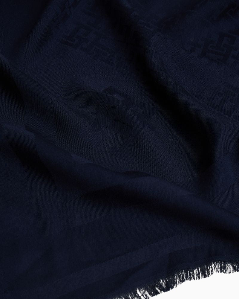 Close-up of Tommy scarf in navy showing lightweight drape and all-over logo pattern