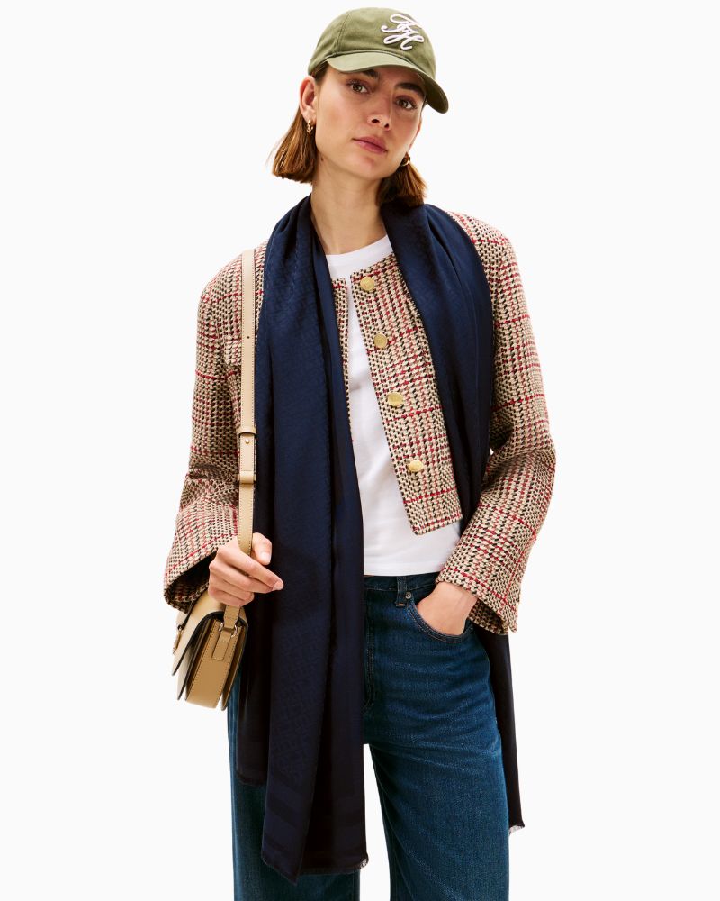 Model view of Tommy scarf in navy showing lightweight drape and all-over logo pattern