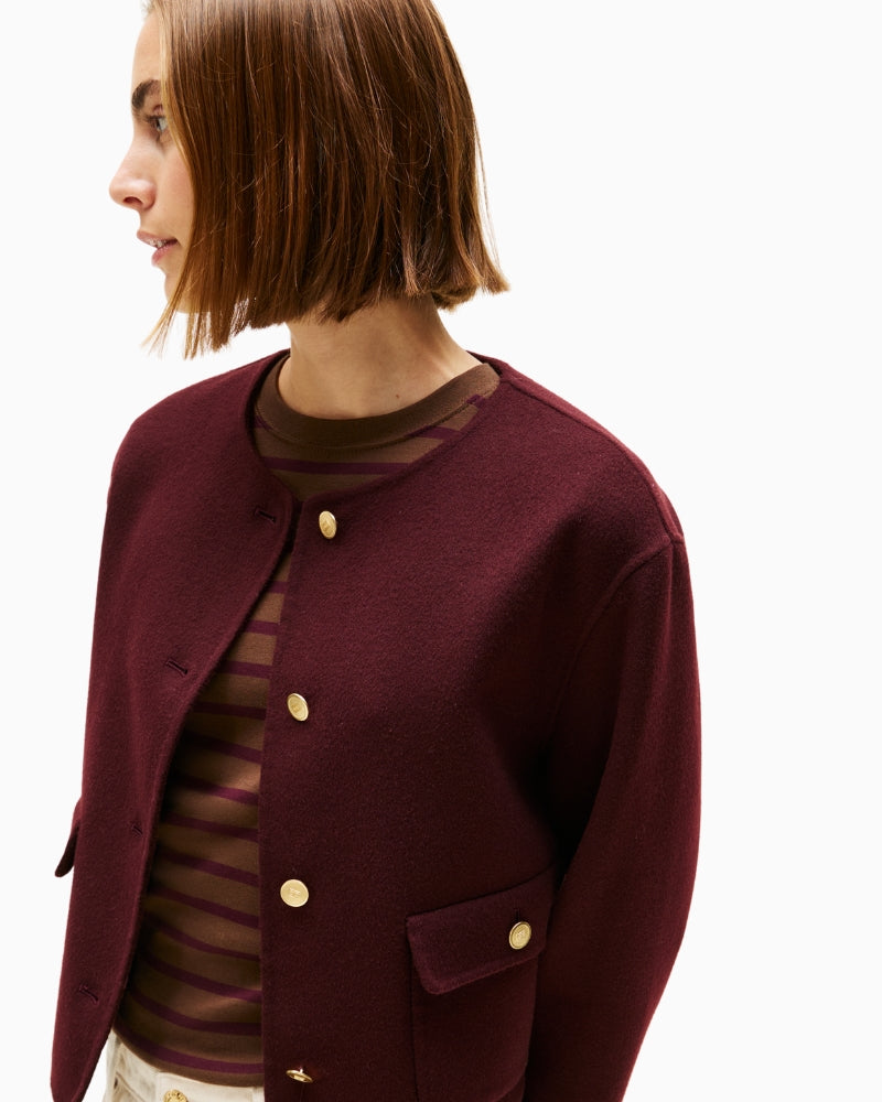 Close-up of button fastening and lapel on burgundy jacket