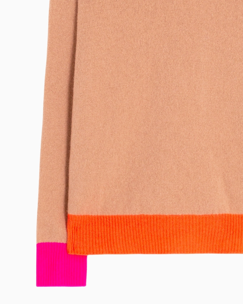 Close-up of orange ribbed collar and fuchsia cuff on Vilagallo wool sweater